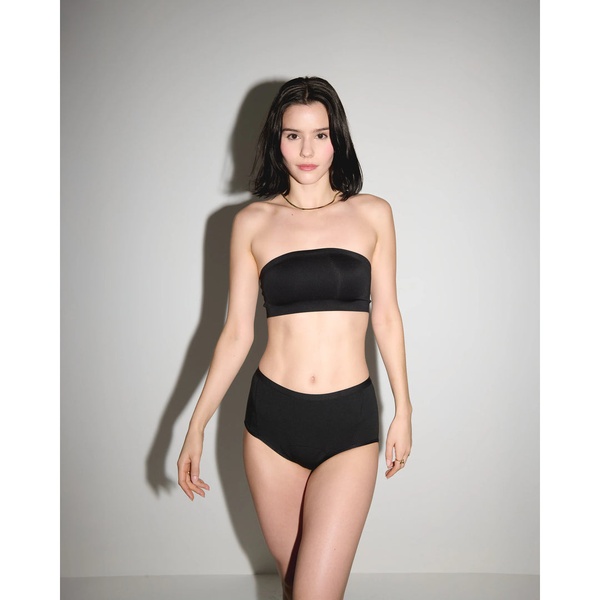 A high-contrast, professional studio shot of a woman wearing a black strapless bra and matching bottoms, emphasizing a clean, product-centric aesthetic.
